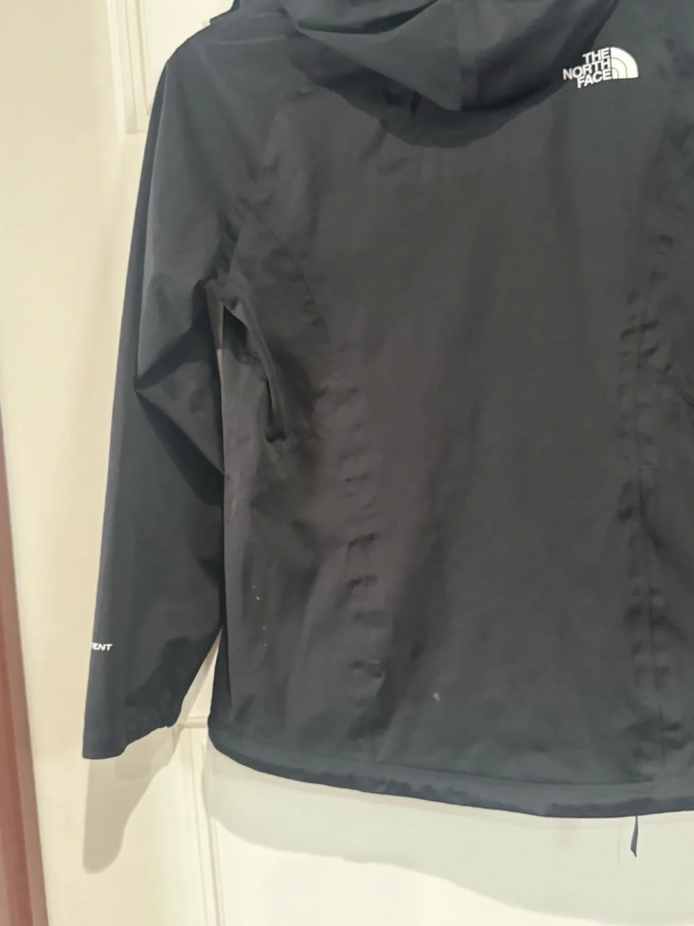 The North Face Black Raincoat with White Zippers and Logo